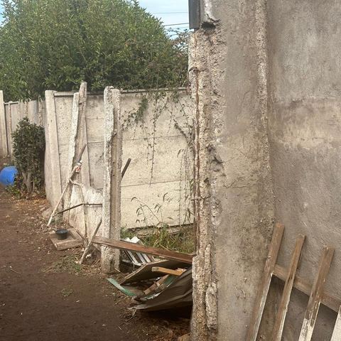Muro perimetral agrietado y desplazado de su base.